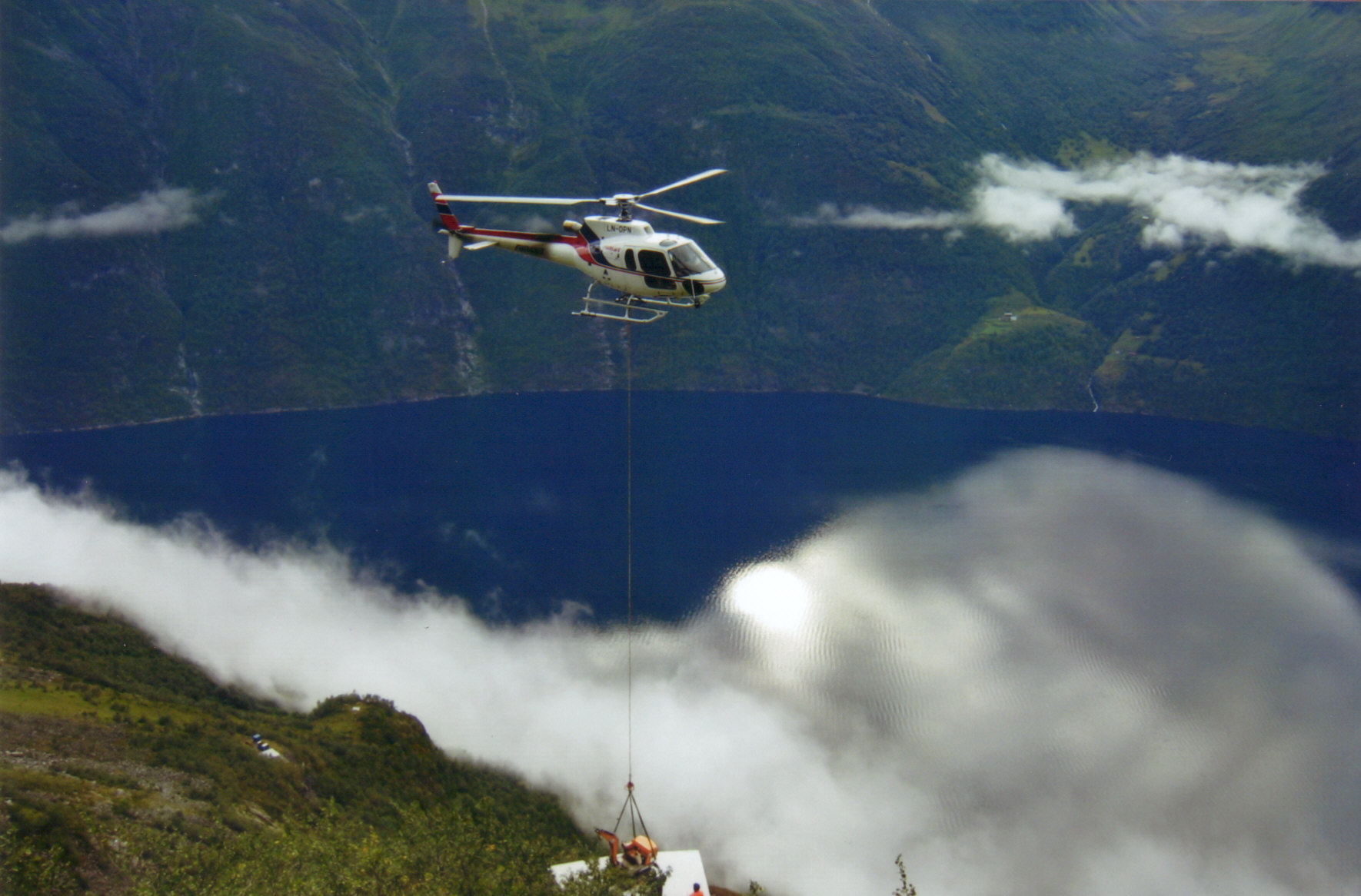 Helikopter flyr over fjorden