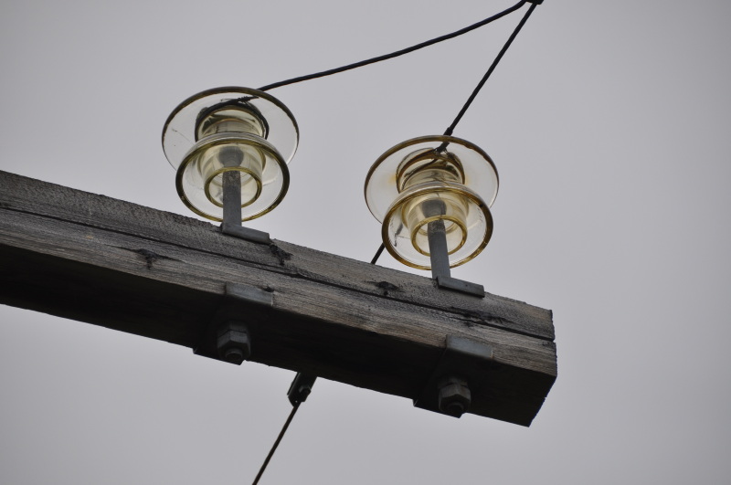 Isolatorer i glass på kraftmast av tre. 