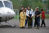 Gruppe med mennesker møtes utenfor helikopter