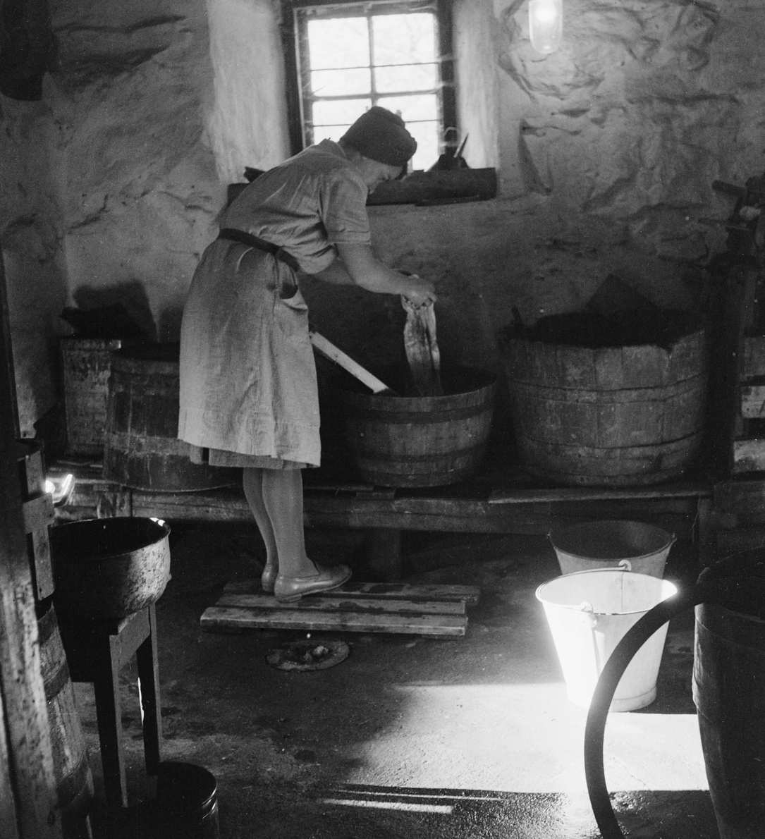 Dame gjør manuell klesvask i en kjeller i Oslo i 1948