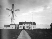 Foto av vindmølle og et bolighus
