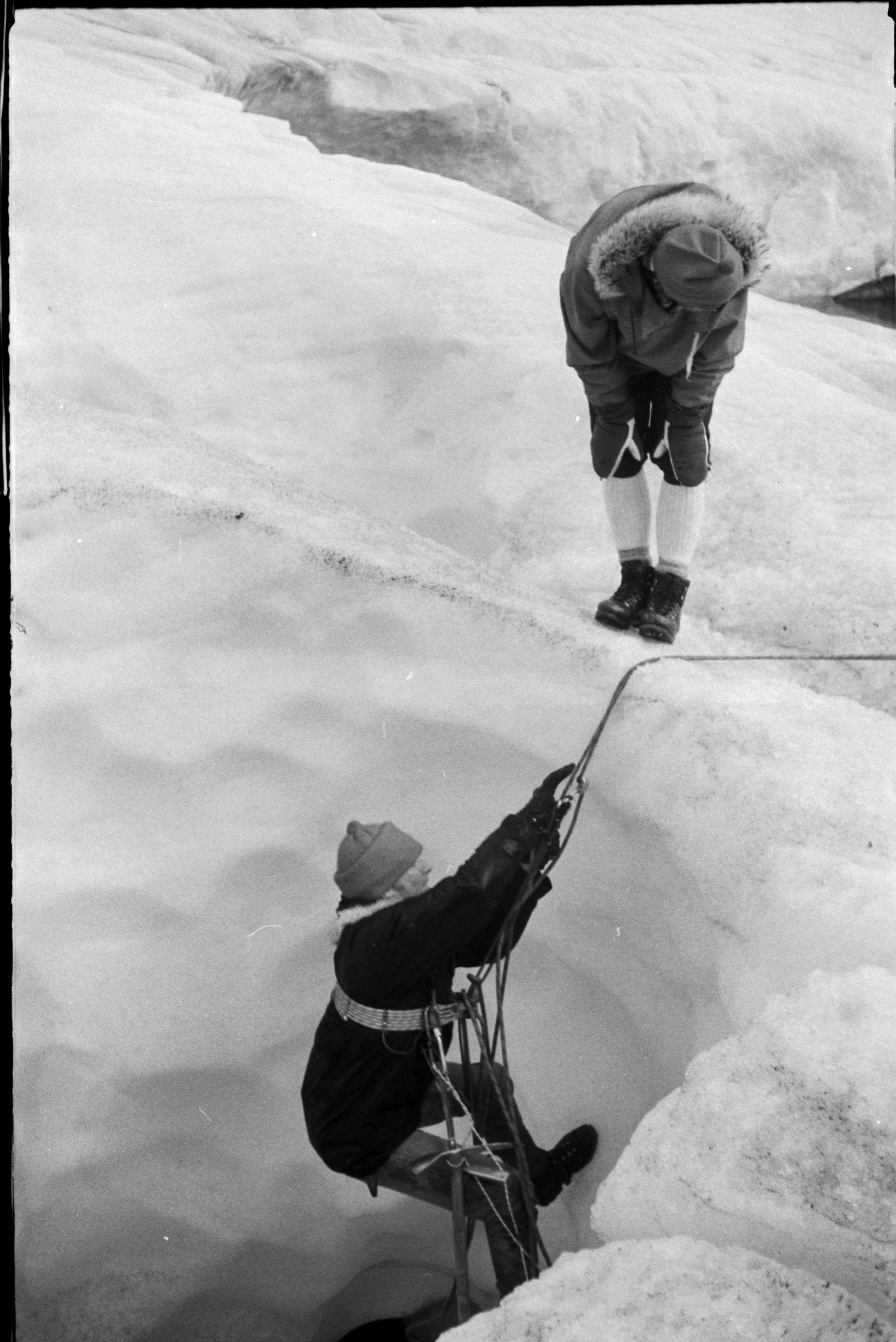 Person på vei opp en bresprekk med tau og sikring