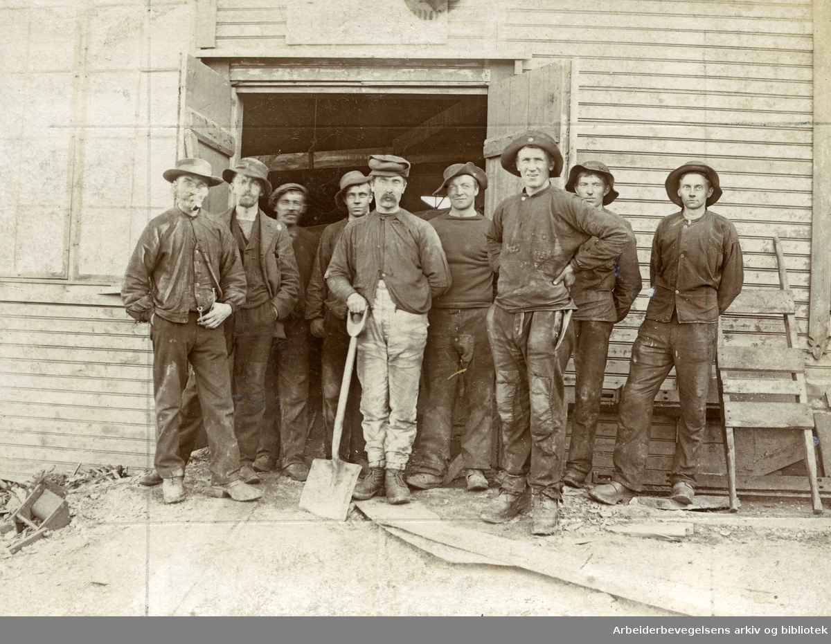 Menn foran trebygning.