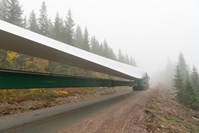 Turbinblad som transporteres langs en skogsbilveg.