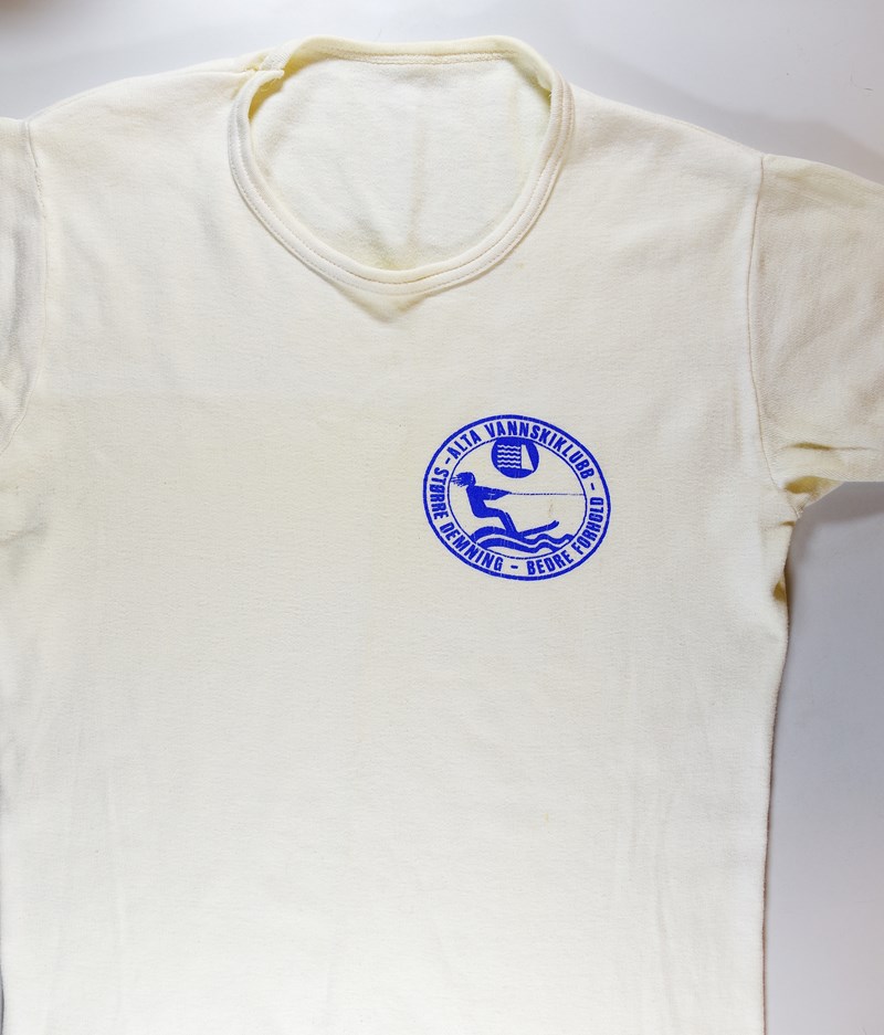 T-skjorte med påskrift: "Alta vannskiklubb. Større demning - bedre forhold"