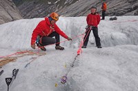 To mennesker på isbre øver på redningsteknikk med sikringsutstyr