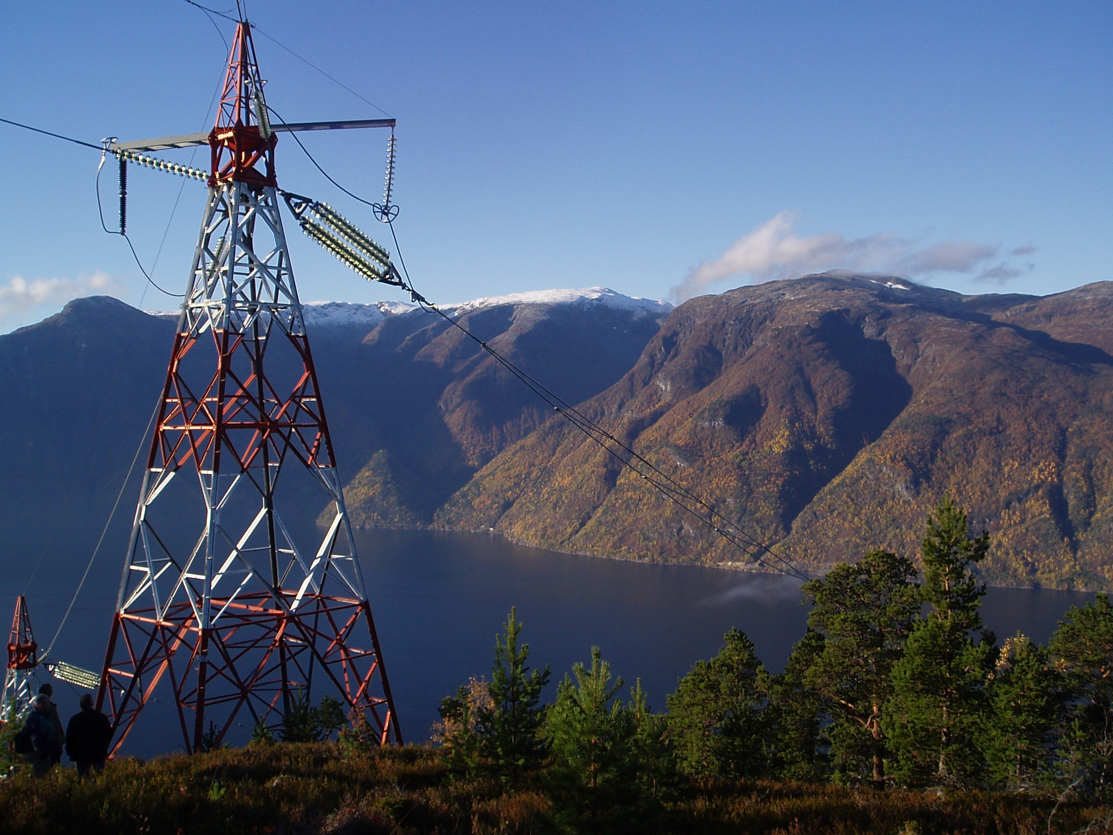 Kraftmast på et fjell med en fjord i bakgrunnen