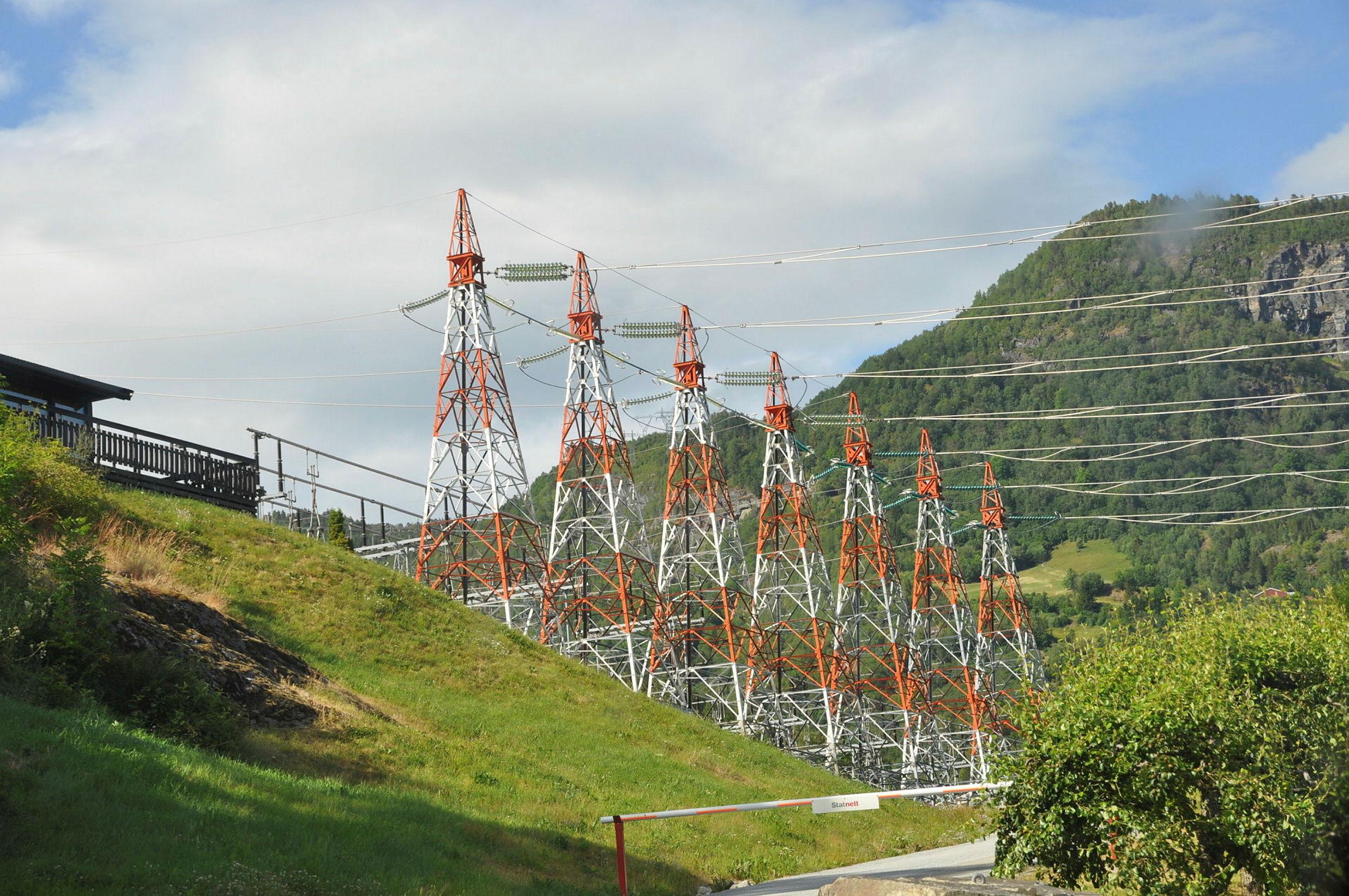 Røde og hvite stålmaster med kraftledninger.