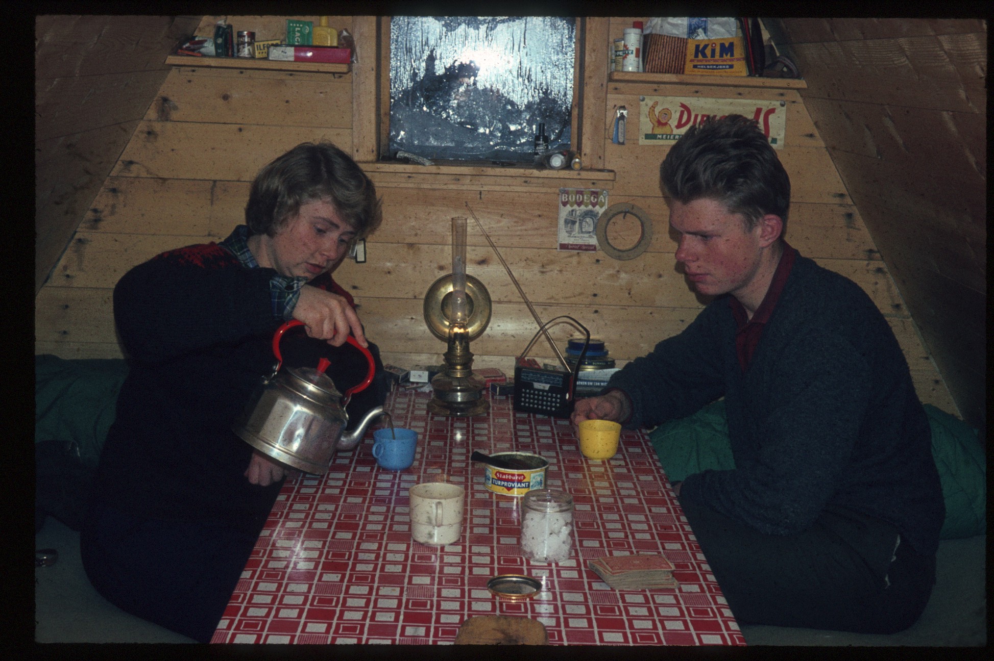 To personar inne i ei trekanthytte.