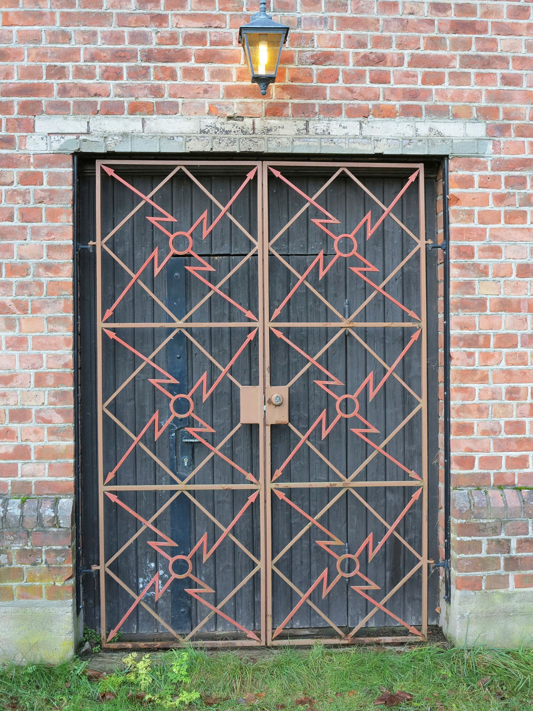 Dør med jerndetaljer på murbygning.