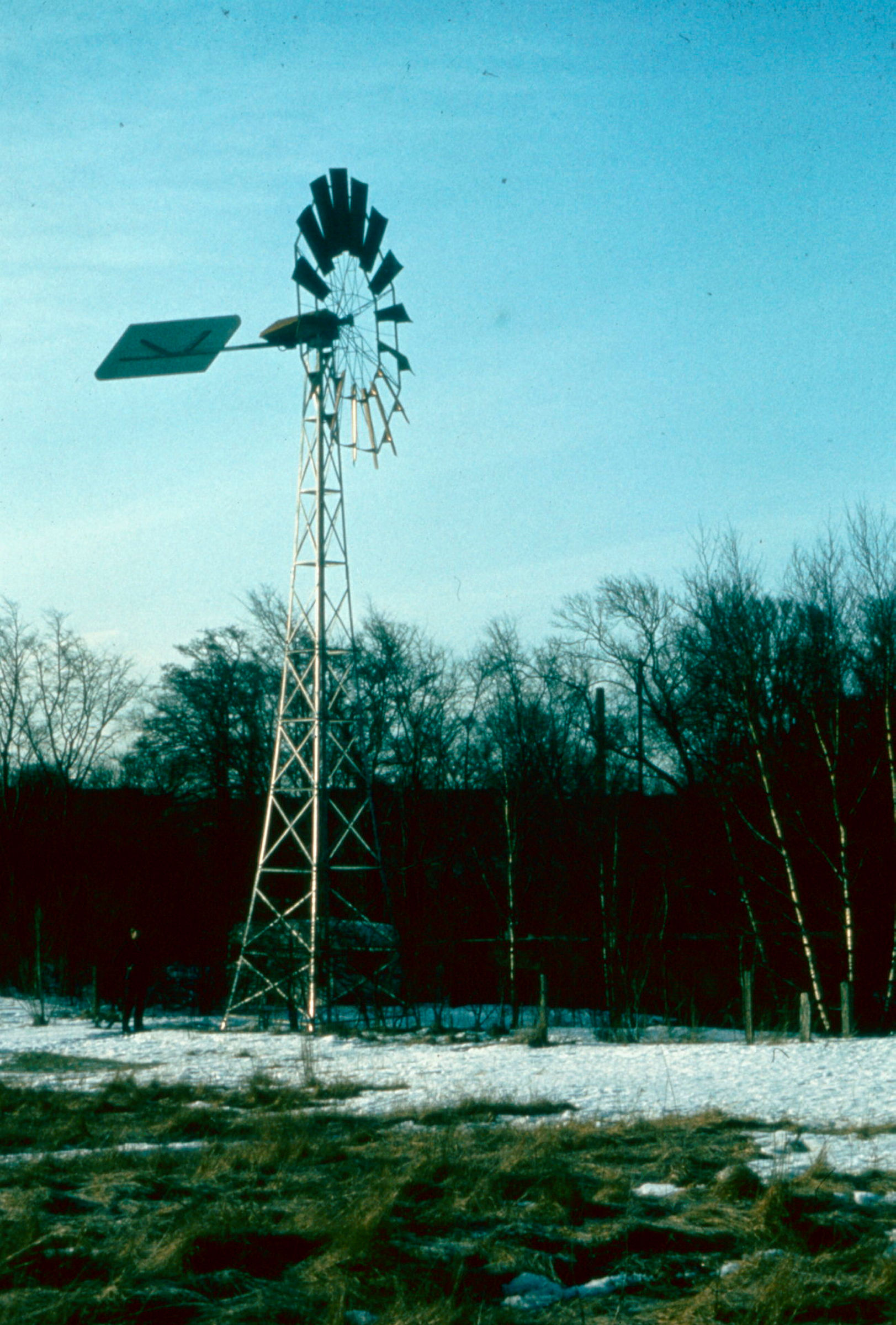 Liten vindturbin i landskap.