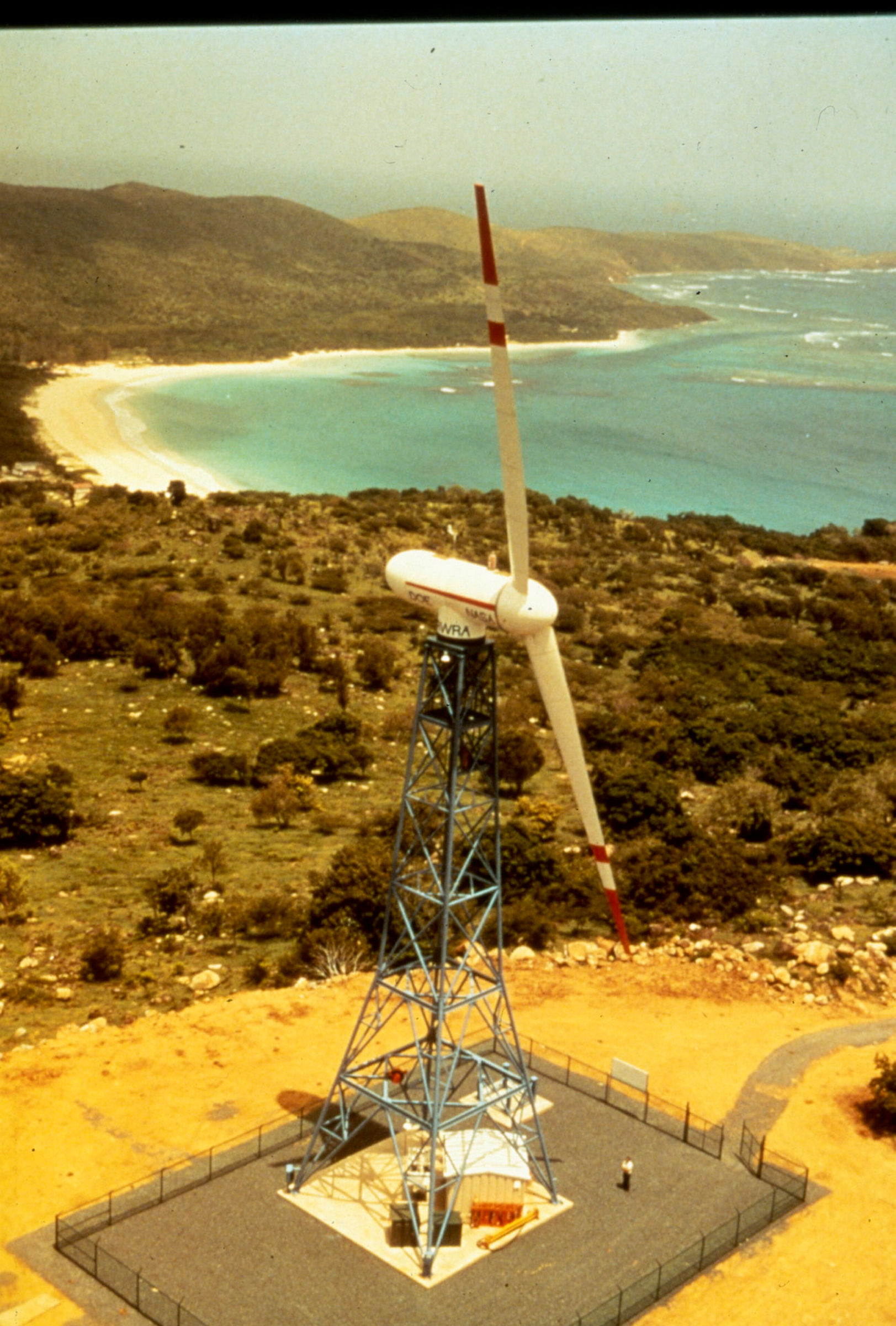 Liten vindturbin i kystlandskap.