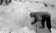 Person borer i is i snøvær