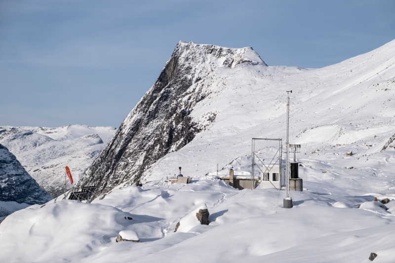 Fjellandskap dekket i snø. Før bratt terreng står en rekke forskjellige instrumenter.