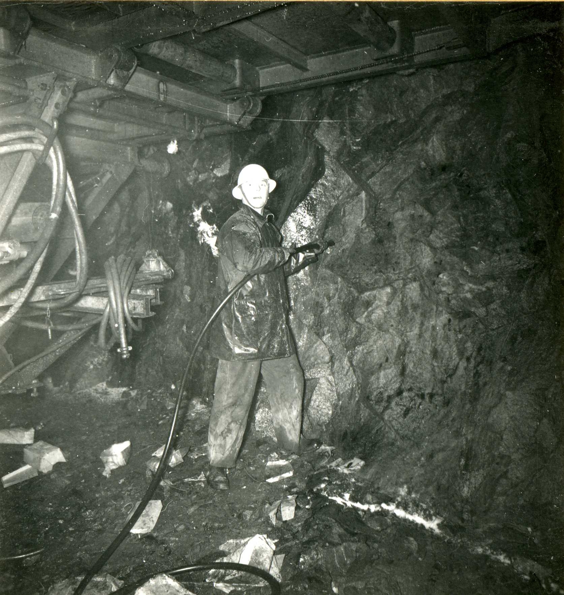 Mann står inne i tunnel og driver sprengingsarbeid
