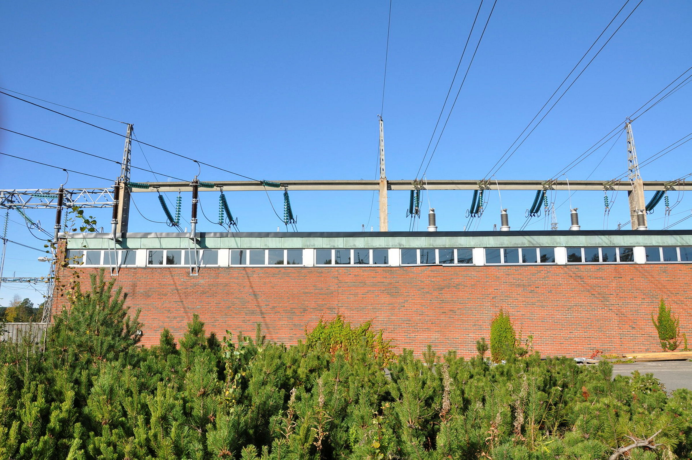 Murbygning med kraftledninger.