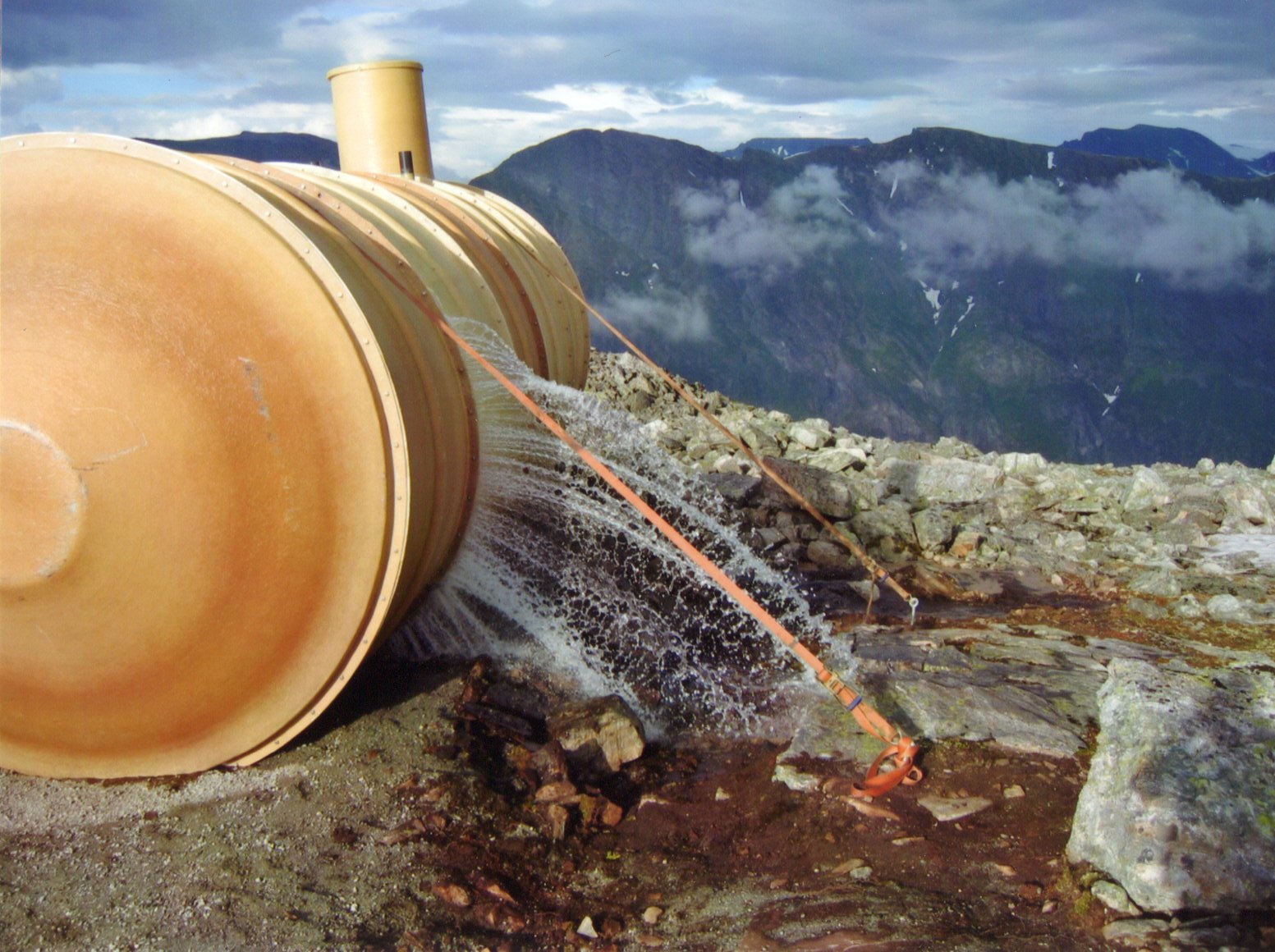 En vanntank oppå en fjelltopp har en åpning som gjør at vann renner ut.